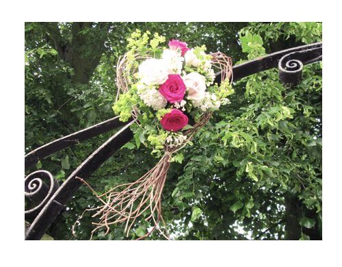 Rustic wicker love heart with cream and bright pink roses